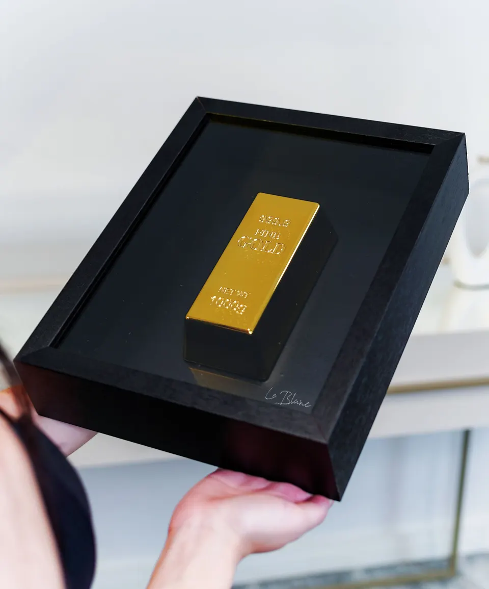 The Golden Bar Of Abundance inclinado com modelo segurando