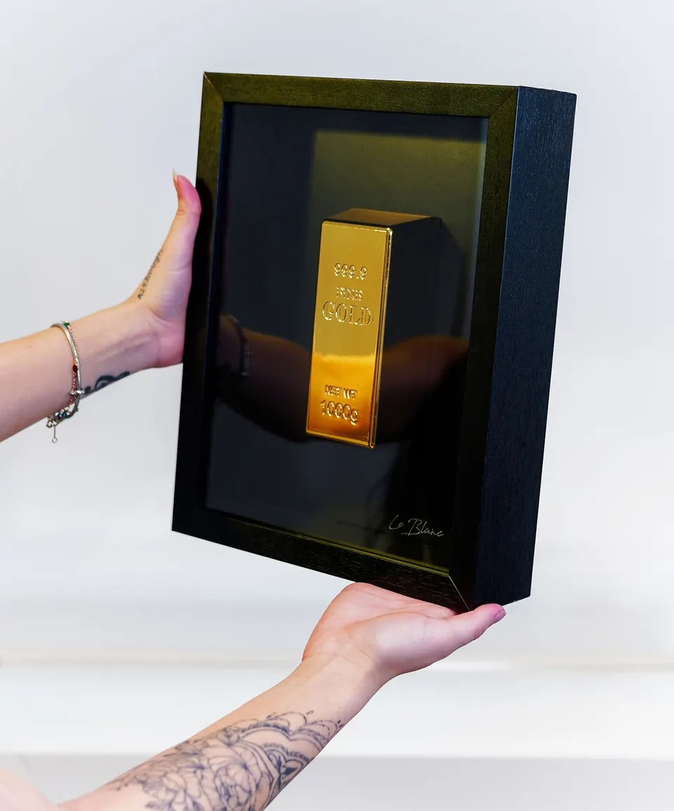 The Golden Bar Of Abundance modelo com tatuagem segurando