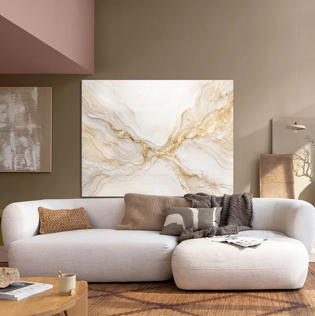 Quadro Nascente Dourada em sala com sofá branco curvo
