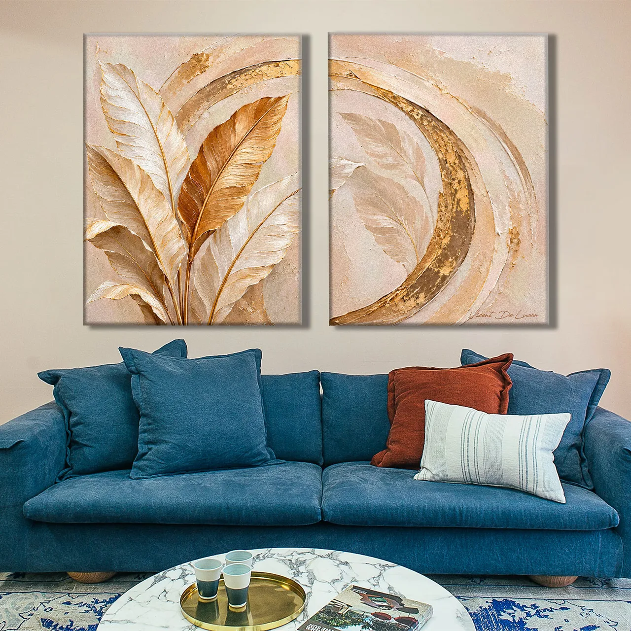 Quadro Abstrato Pinceladas e Folhas Douradas 2 peças, de Vicent de Lucca, folhas creme e cobre e arco dourado, acima de sofá azul