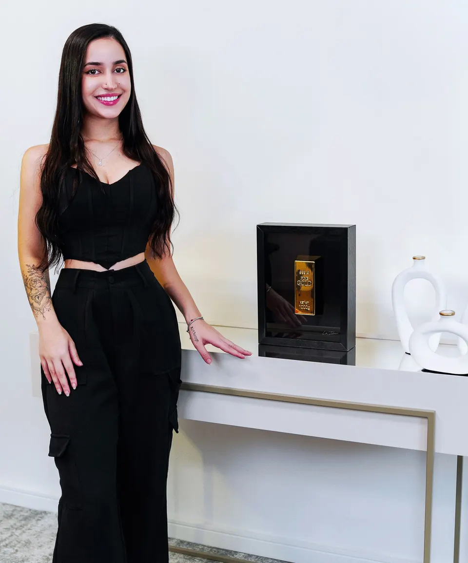 The Golden Bar Of Abundance no aparador com modelo em pé ao lado